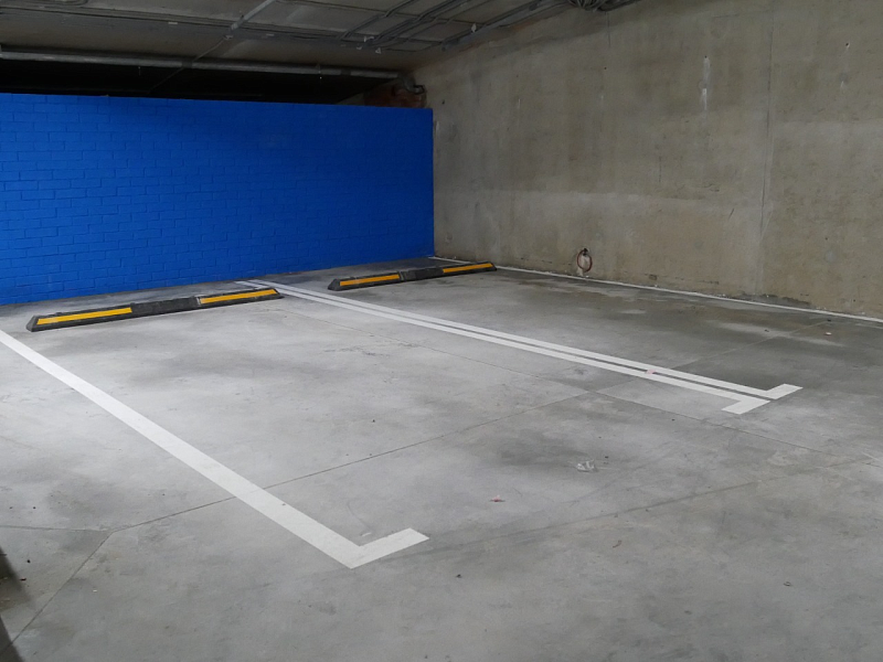 Машиноместо на подземной парковке, обозначенное с помощью дорожной эмали Машиноместо на подземной парковке, обозначенное с помощью дорожной эмали