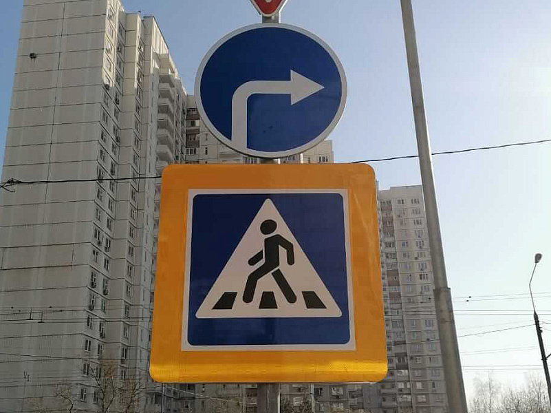 Обозначение пешеходного перехода дорожным знаком на желтом фоне Обозначение пешеходного перехода дорожным знаком на желтом фоне