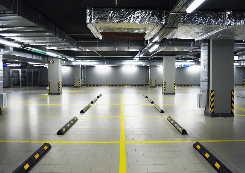 Подземная парковка, оснащенная отбойниками для колес Подземная парковка, оснащенная отбойниками для колес